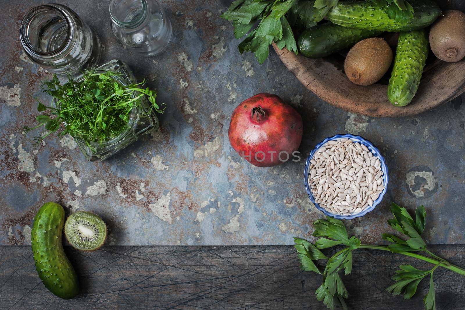 Ingredients for green vegan smoothie with pomegranate on the rustic table
