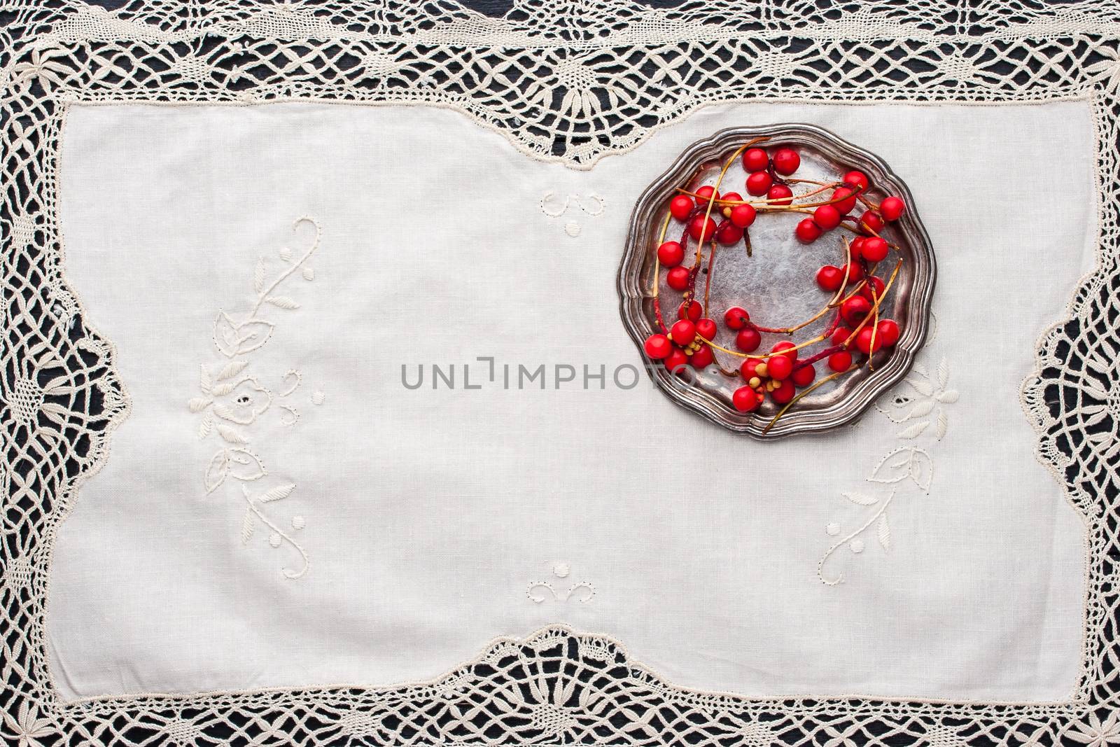 Sprig of red berries  on the  old vintage  lace napkin