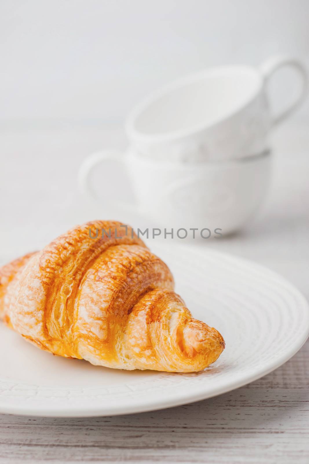 Croissant on the white plate by Deniskarpenkov