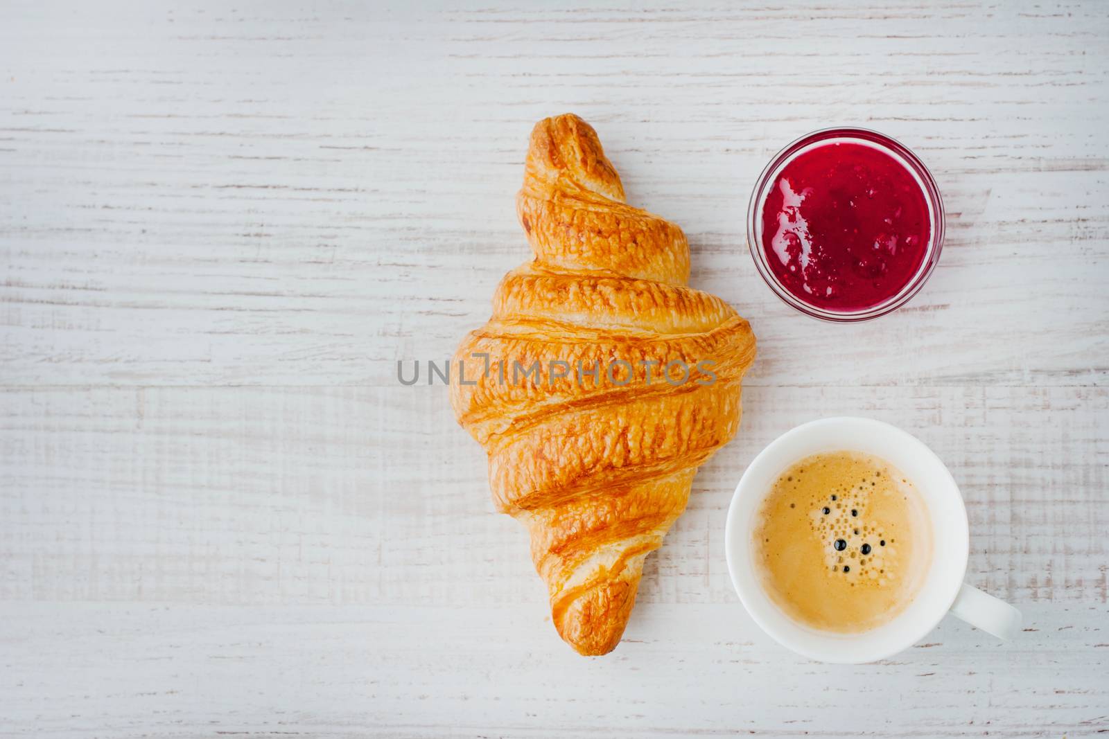 Croissant with cup of coffee and jam  top view