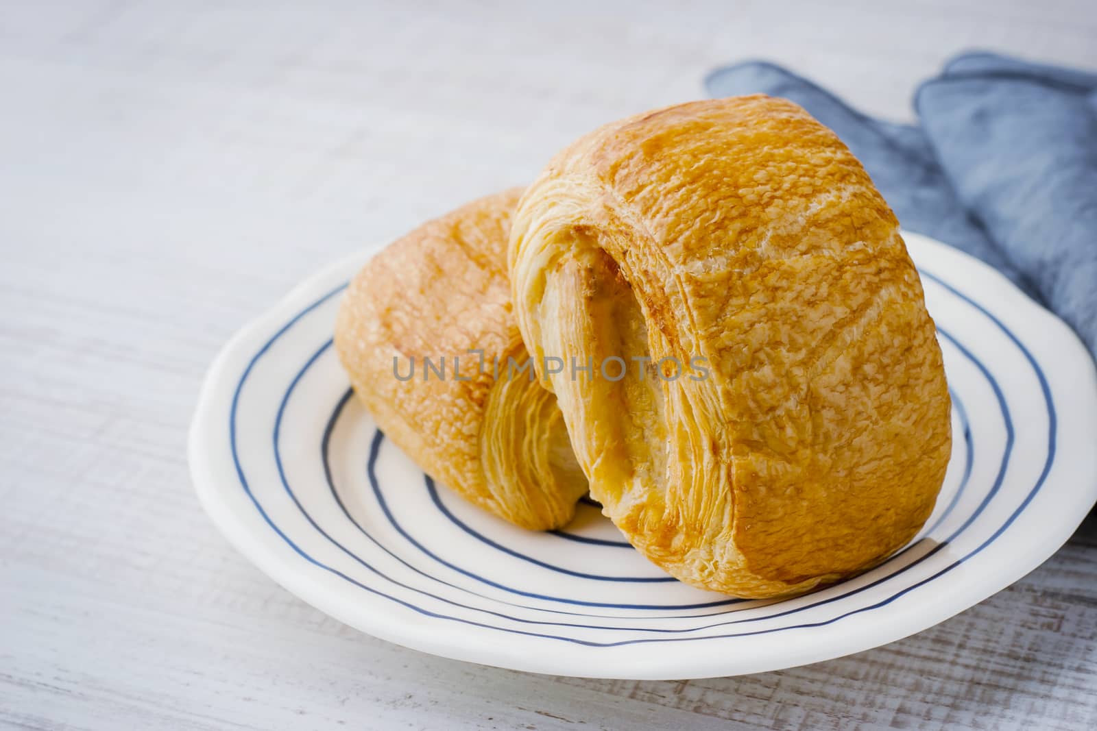 Two cream puff on the ceramic plate with napkin