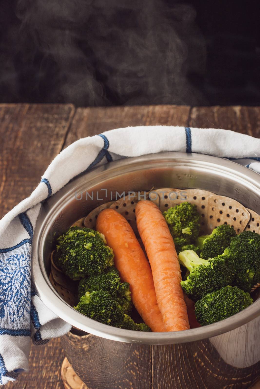 Steamed broccoli and carrots  in the pot with steam