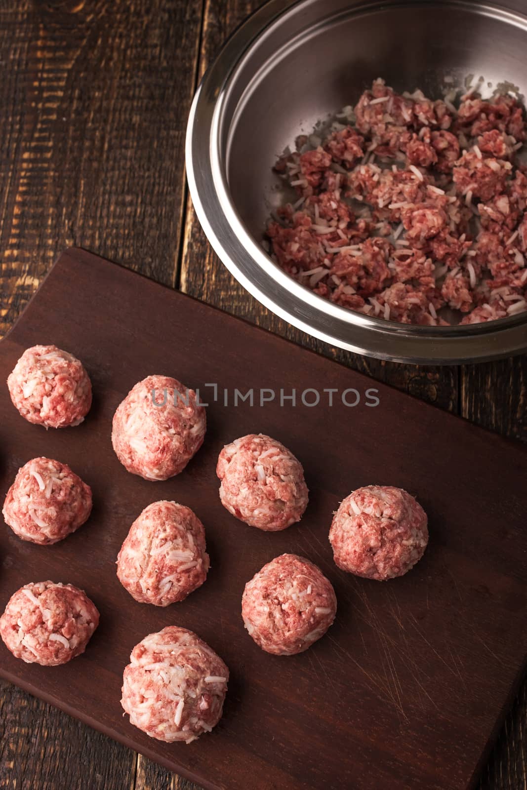 Meatballs on the wooden board with stuffing in a pan top view vertical