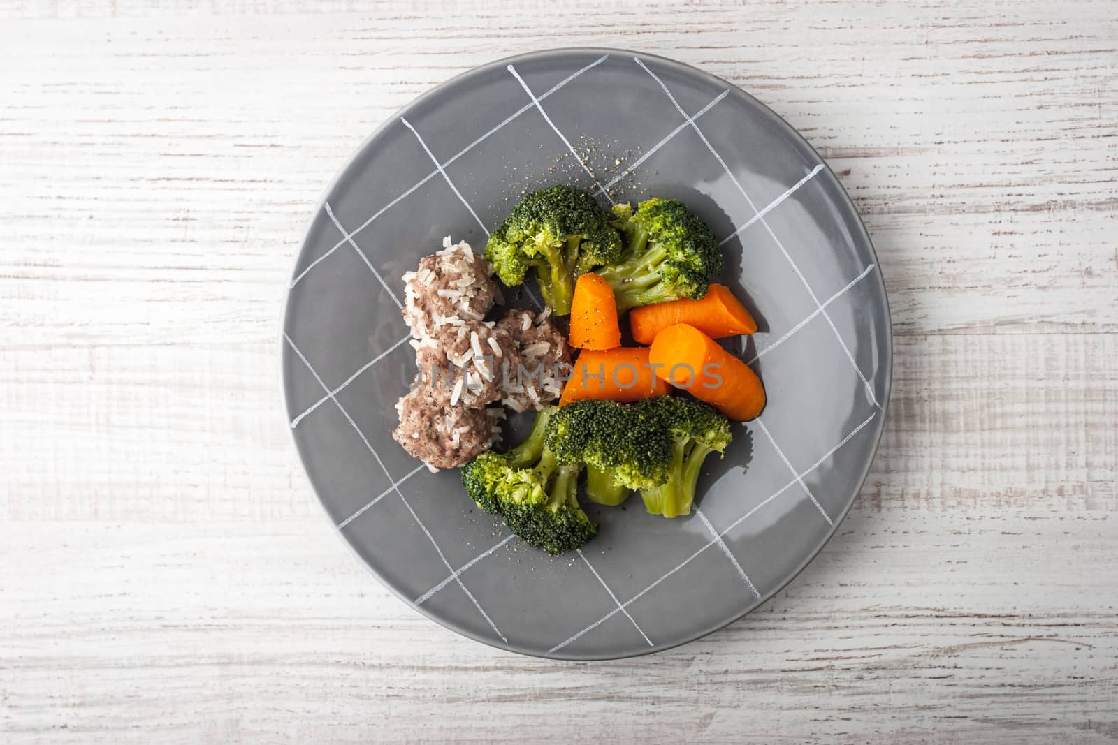 Meatballs with steamed vegetables on the gray plate top view