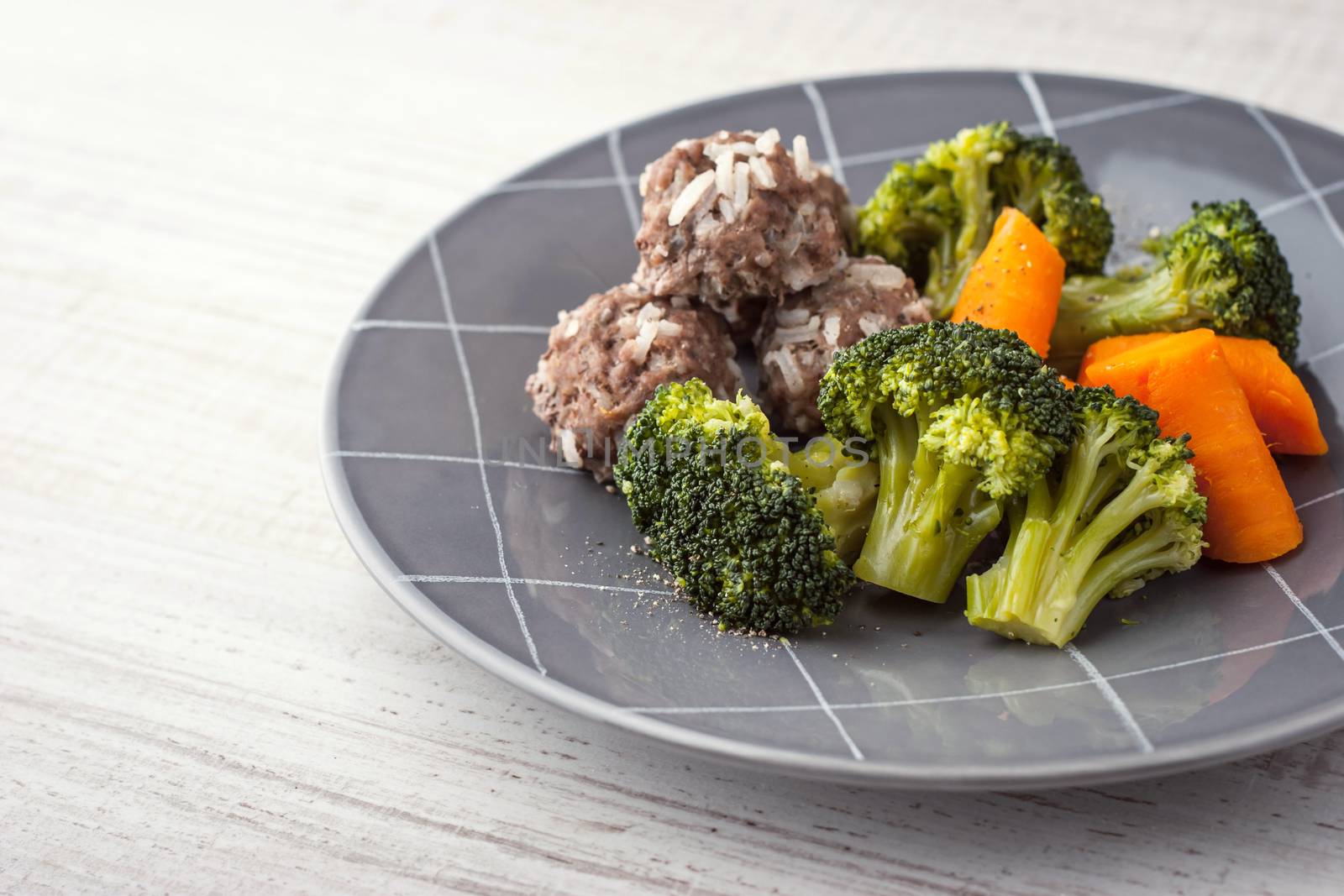 Carrots and broccoli with meatballs on the grey plate horizontal