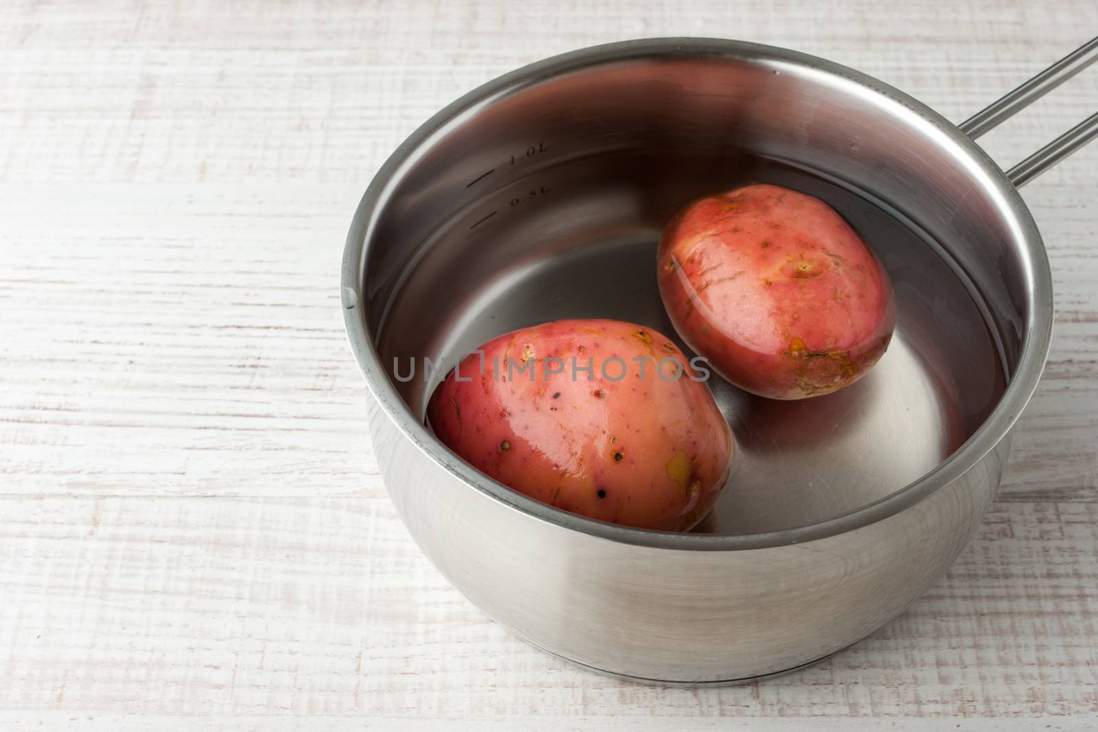Potatoes in water in a metal pan horizontal