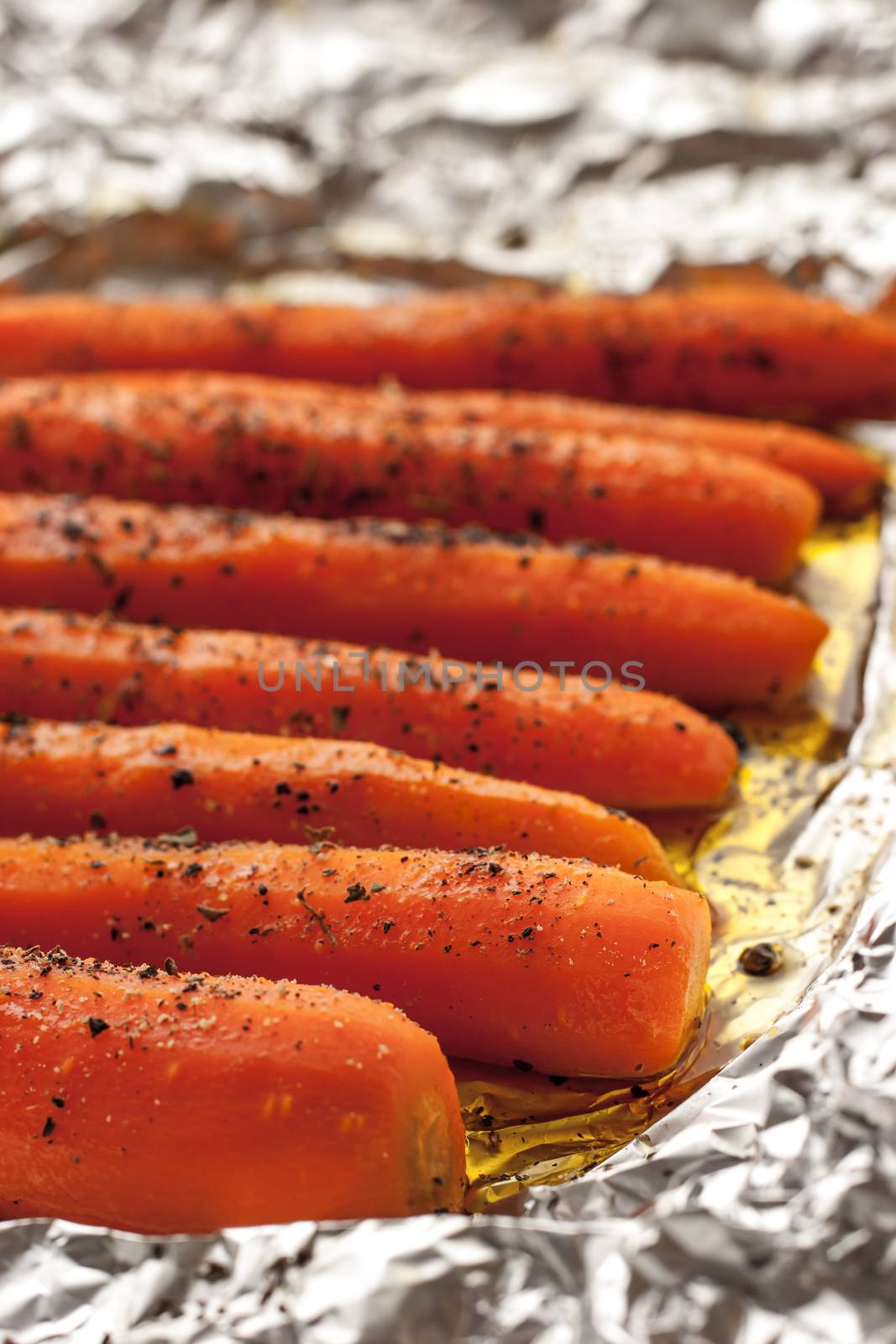 Baked carrots with black pepper on a sheet of foil vertical