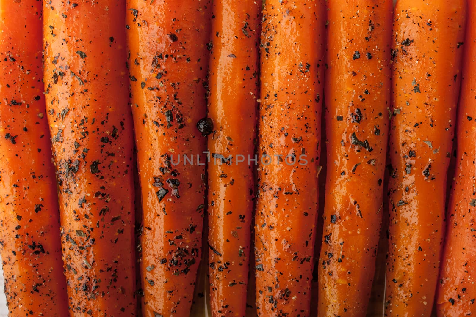 Baked carrots with black pepper and herbs  close-up background horizontal
