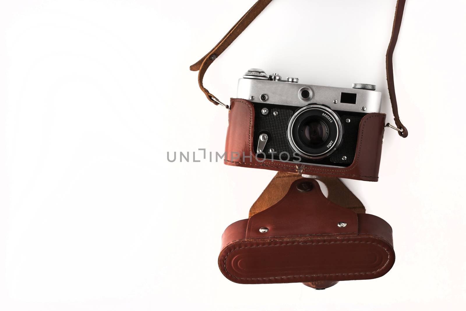 Old vintage camera  in the brown case on the white background horizontal