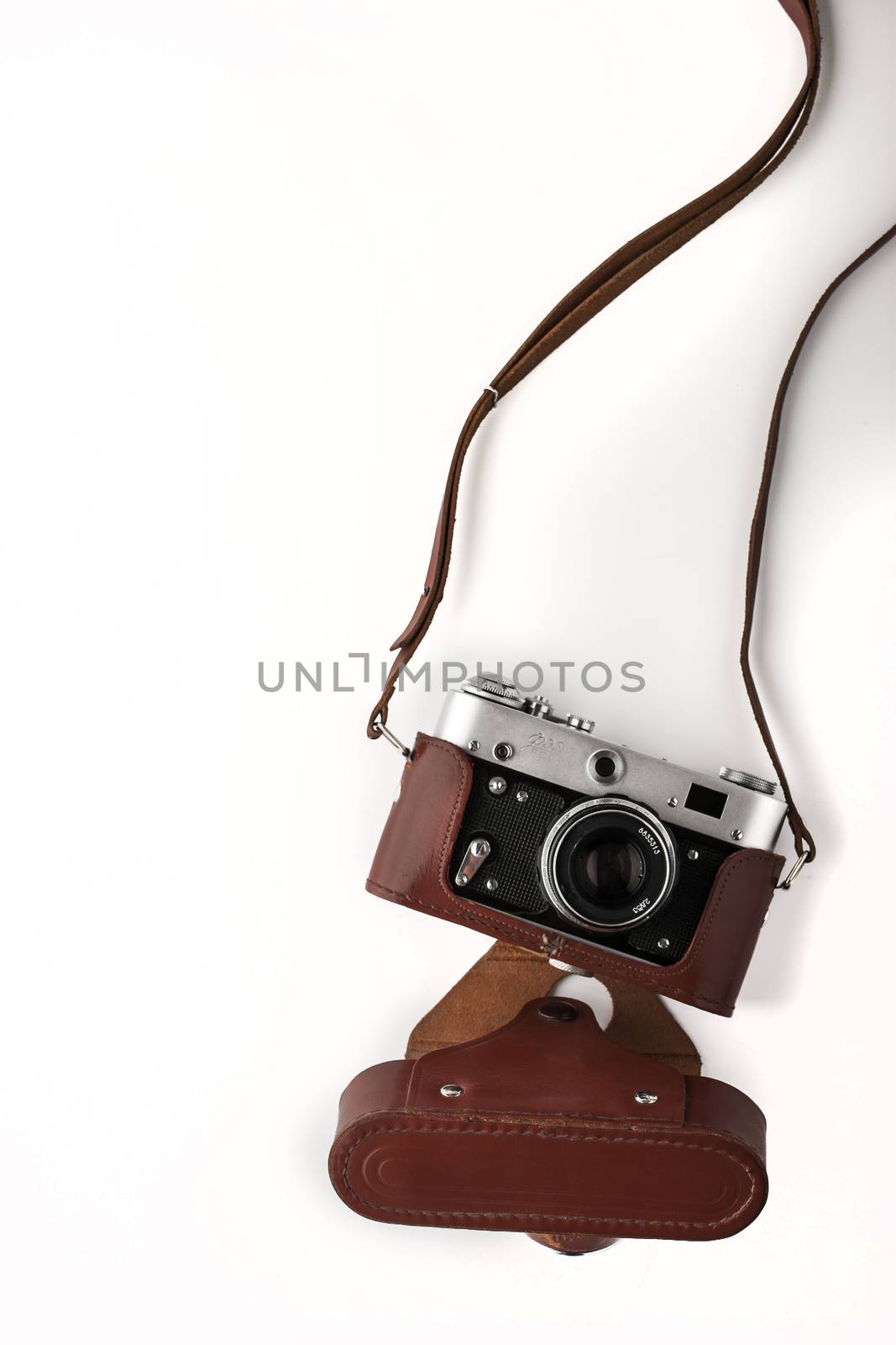 Old vintage camera  in the brown case on the white background vertical