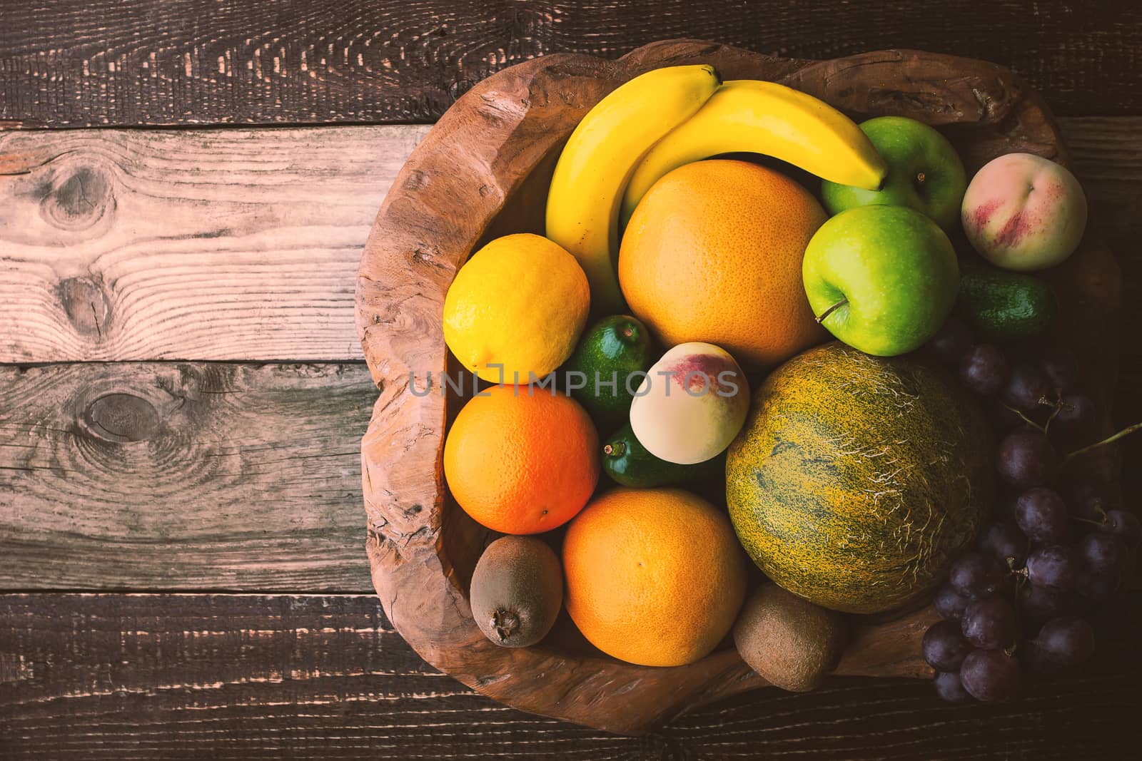 Fruit mix on the wooden bowl top view horizontal