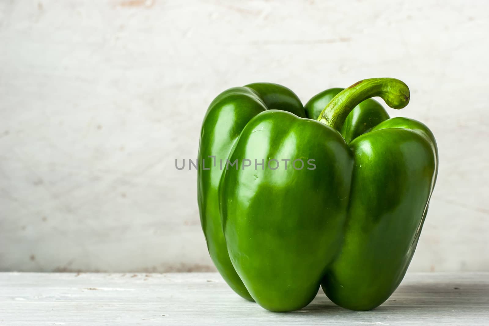 Green pepper on the white table by Deniskarpenkov