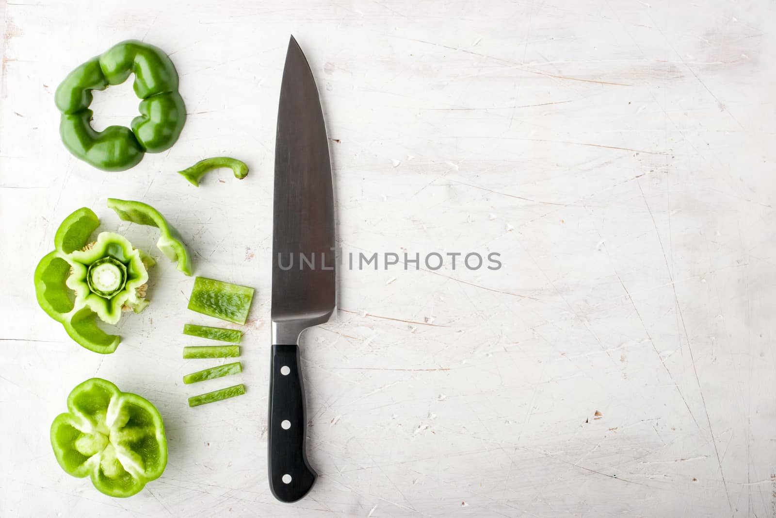 Sliced sweet pepper with knife on the white table horizontal