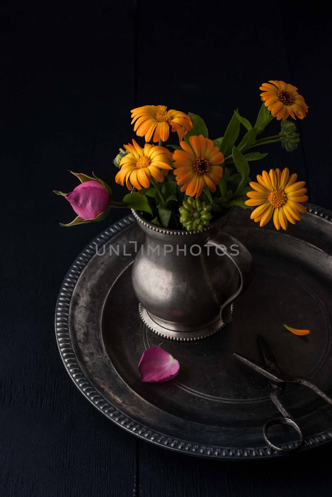 Bouquet of flowers in the old metal jug on the vintage tray