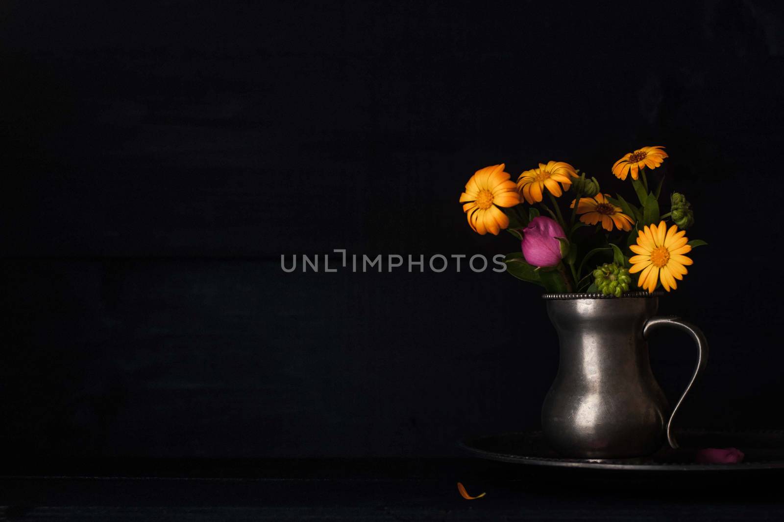 Bouquet of flowers in the old metal jug horizontal