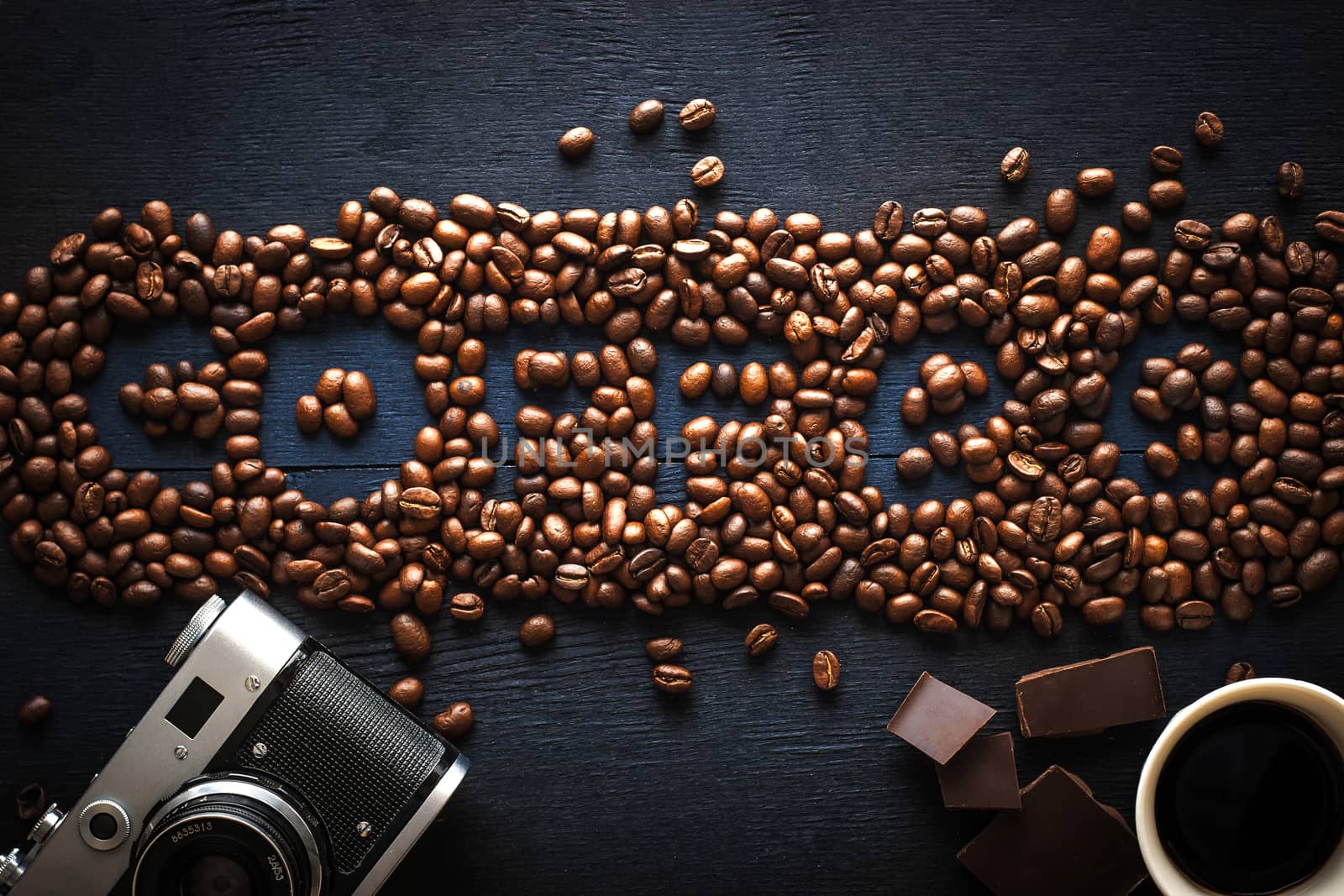 Coffee word made by coffee beans with camera  chocolate and cup of coffee