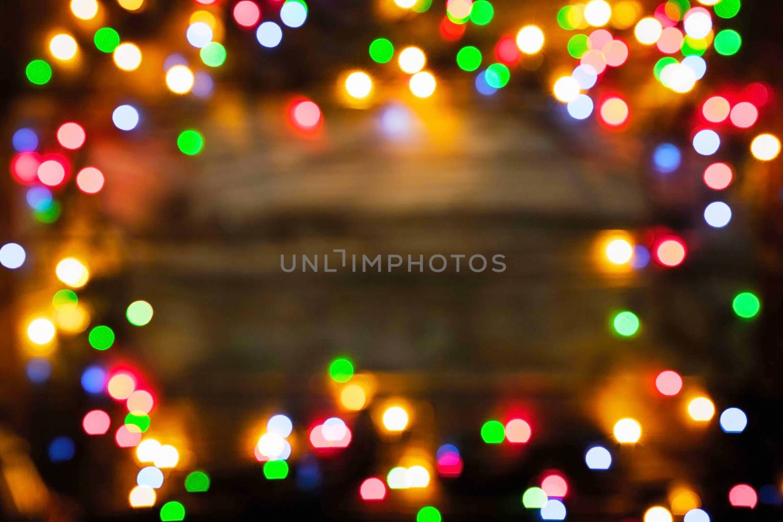 Blurred frame of the colorful Christmas festoon on the wooden board