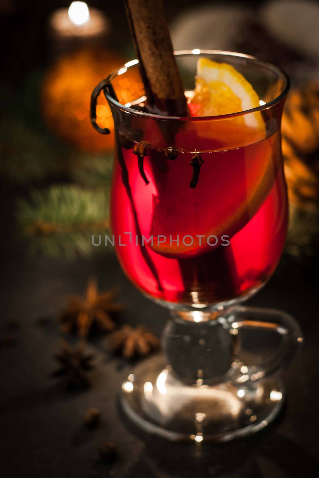 Mulled wine with spices and blurred Christmas decorations
