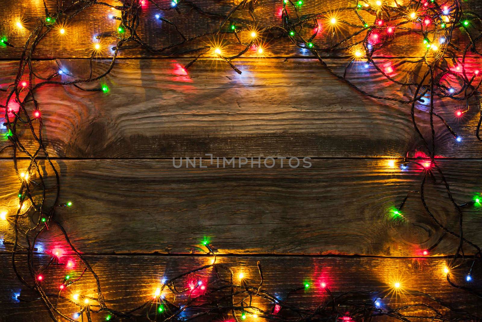 Frame of the colorful Christmas festoon on the wooden board