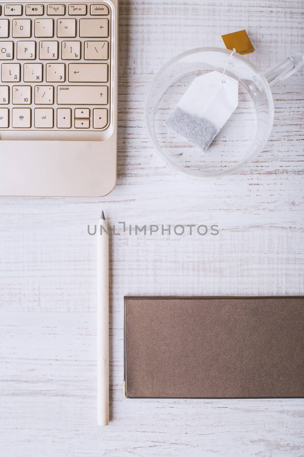 Laptop and notebook and a cup on a wooden table vertical