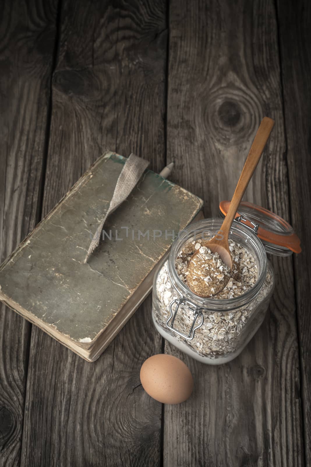 Book of recipes and ingredients for cookies on a wooden table vertical