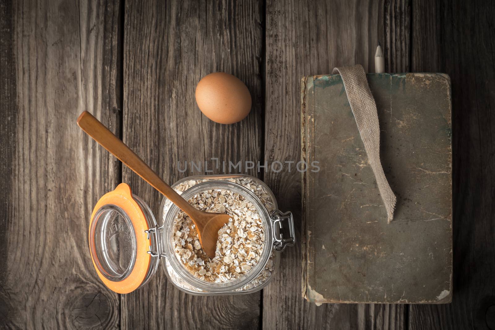 Book of recipes and ingredients for cookies on a wooden table horizontal super still life