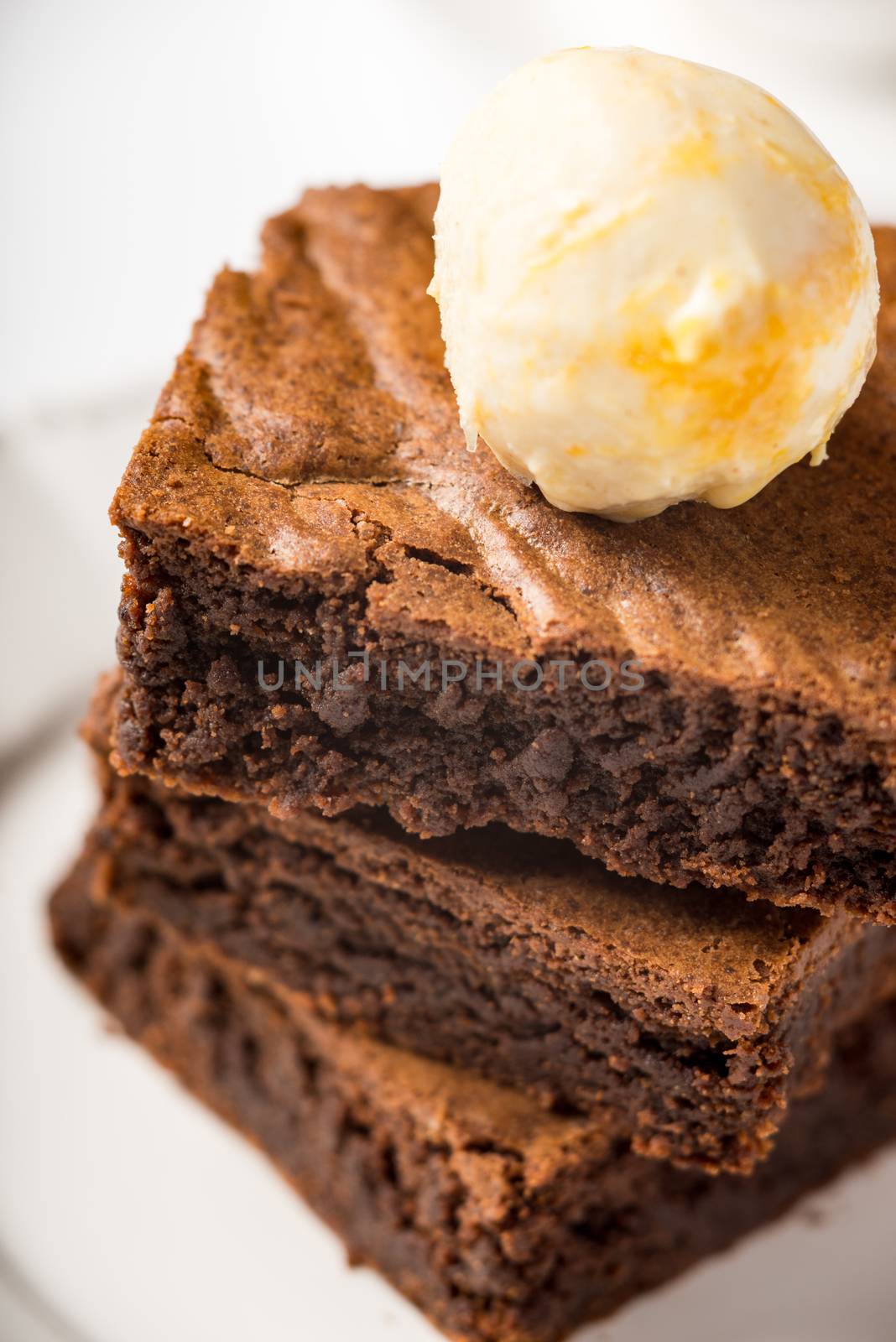 Brownie with ice cream on a white ceramic plate vertical  