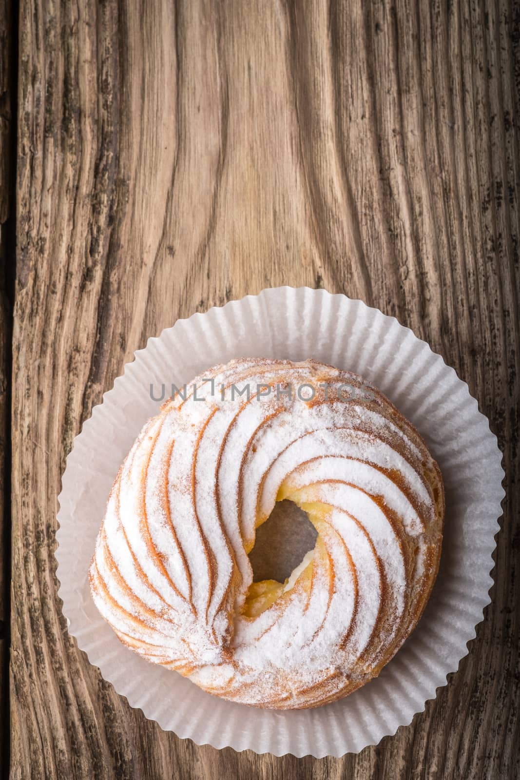 Cake in powdered sugar on a wooden table horizontal