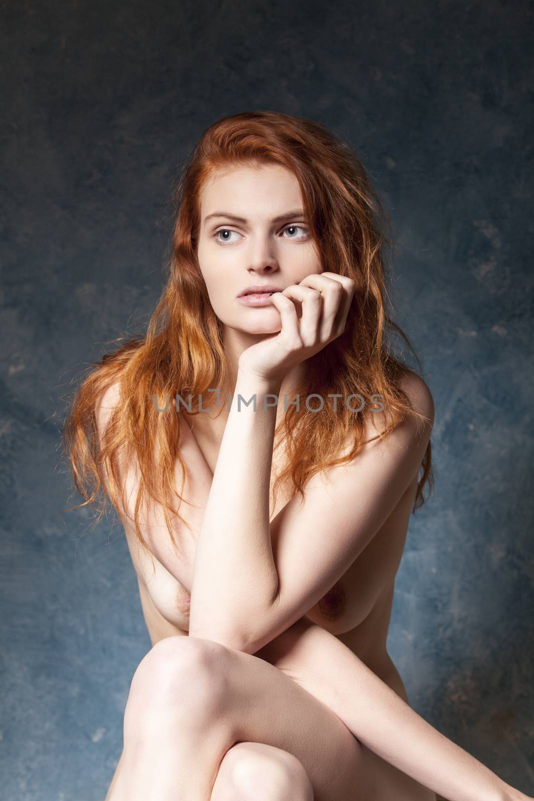 sitting nude redhead on blue