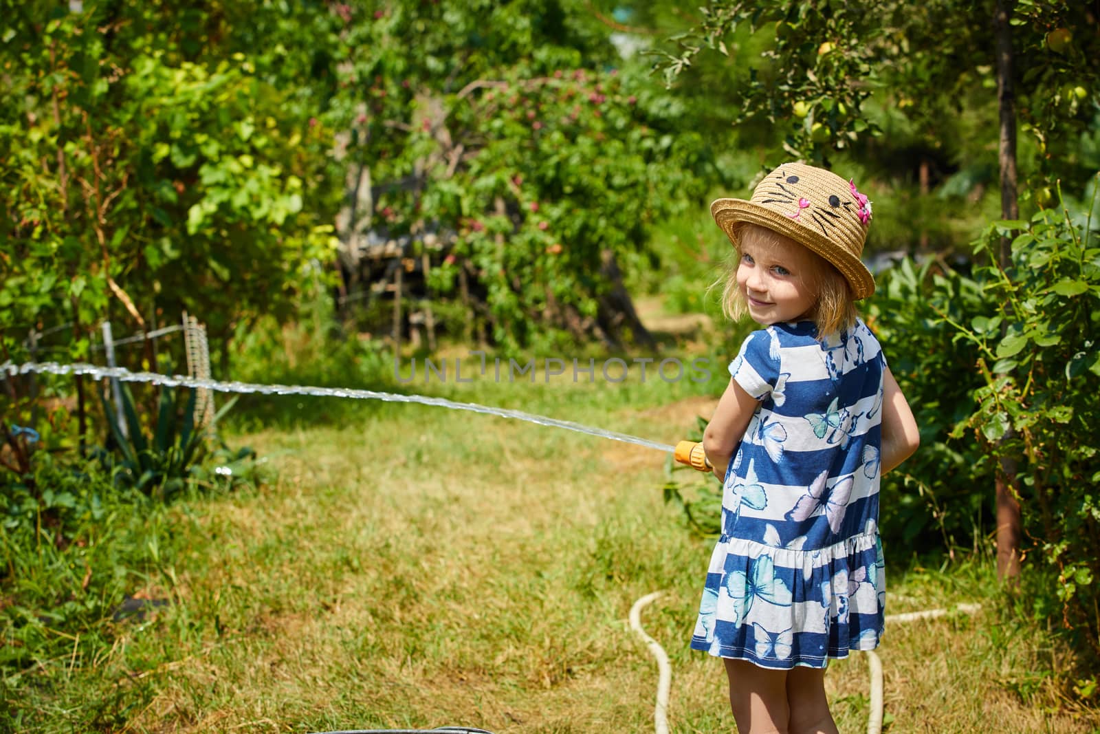 Little happy girl watering garden by sarymsakov
