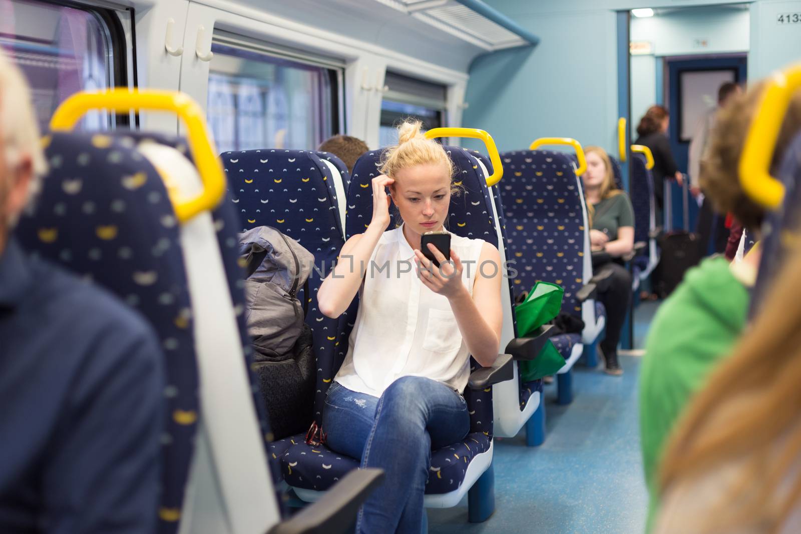 Woman workin on smart phone while traveling by train. Business travel concept.