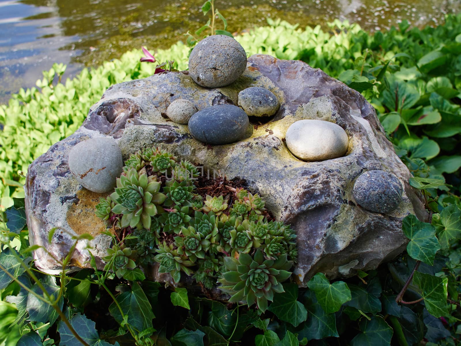 Beautiful creative decoration made of stone in a lush green garden