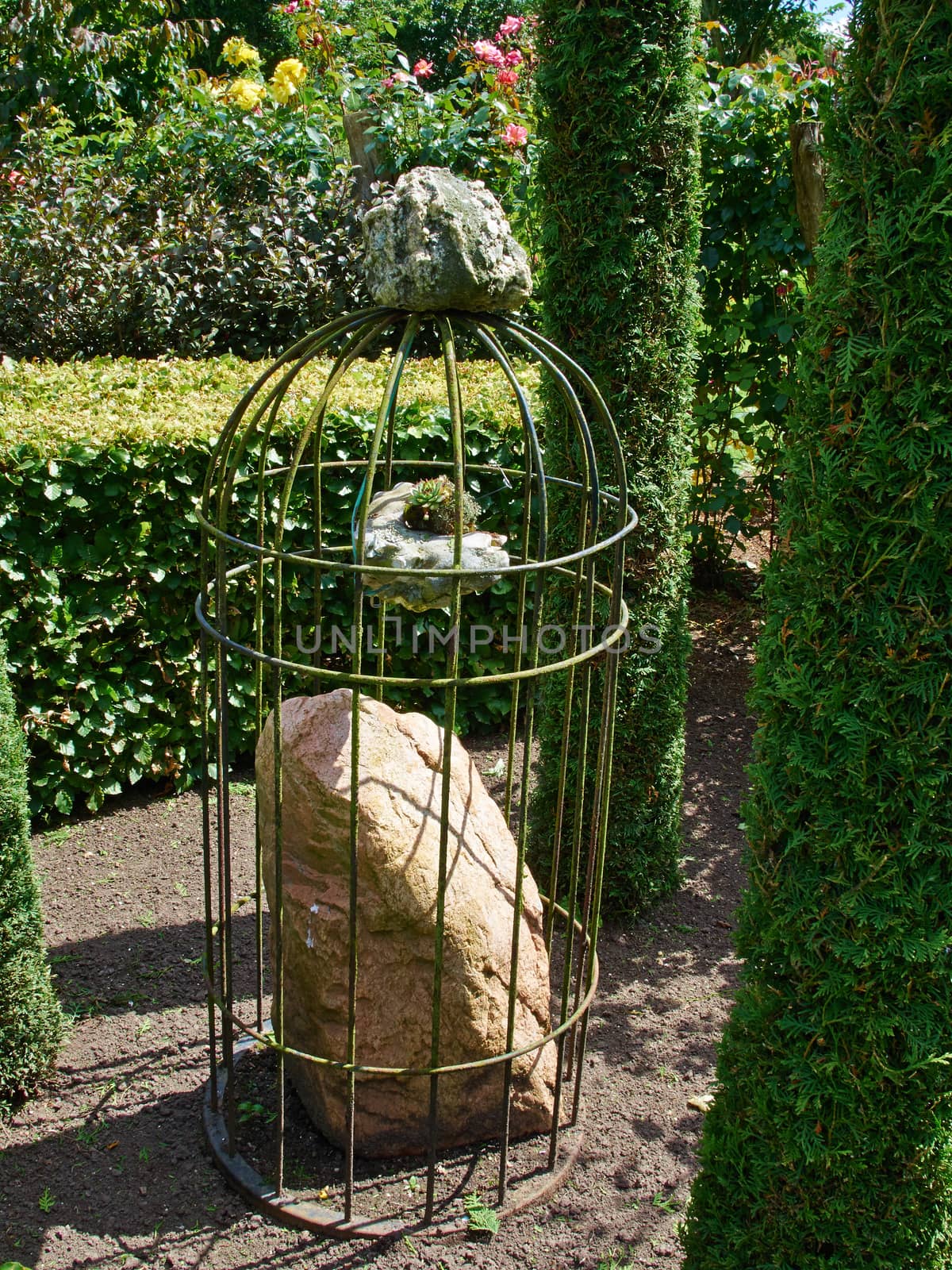 Beautiful creative decoration made of stone in a lush green garden   