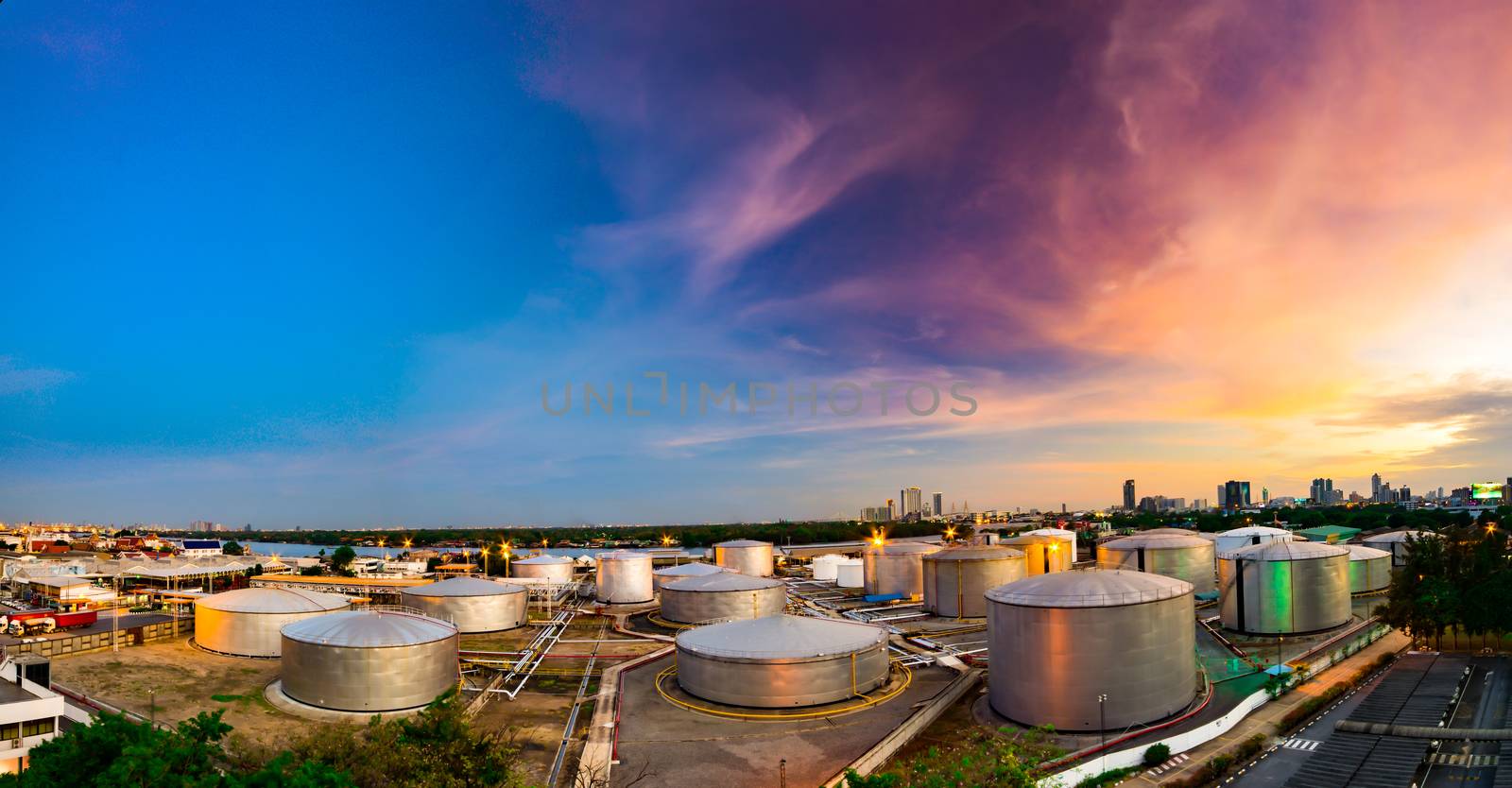 Industrial oil tanks in a refinery at twilight by ahimaone