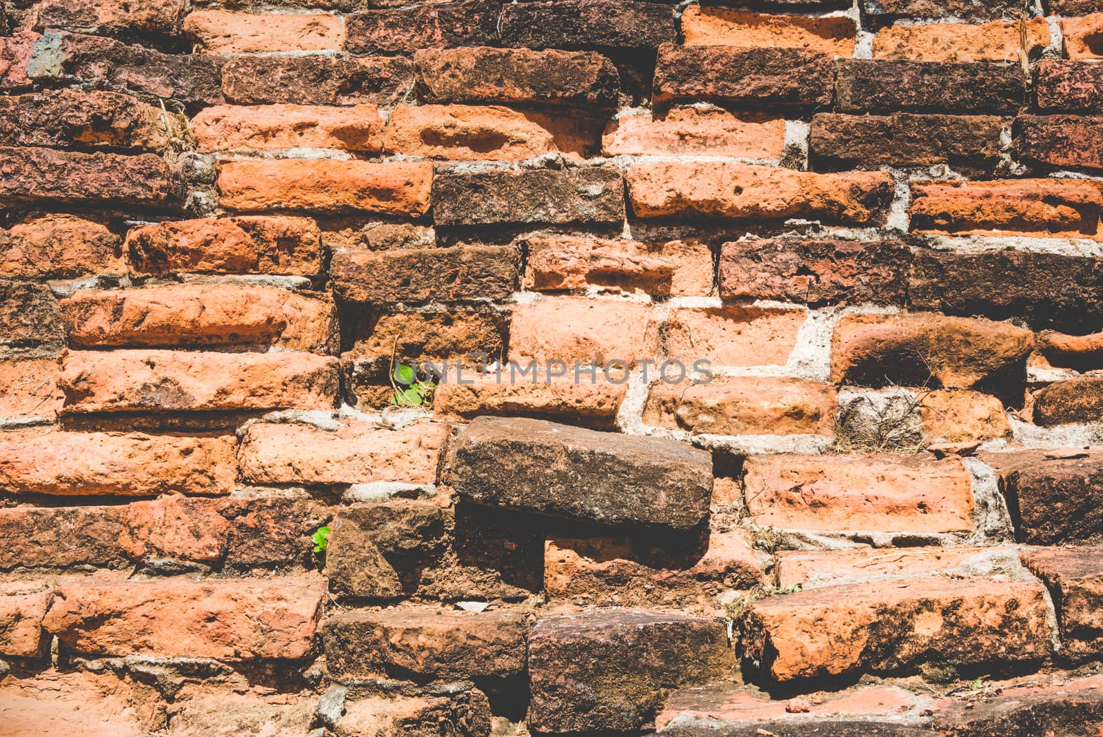 Weathered texture of stained old dark brown and red brick wall background