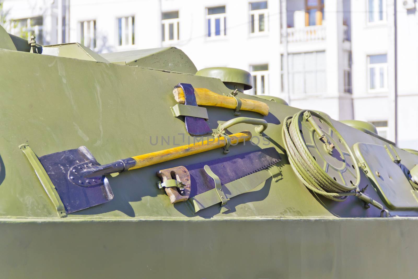 Military machine at the exhibition under open sky with shovel, ax and saw