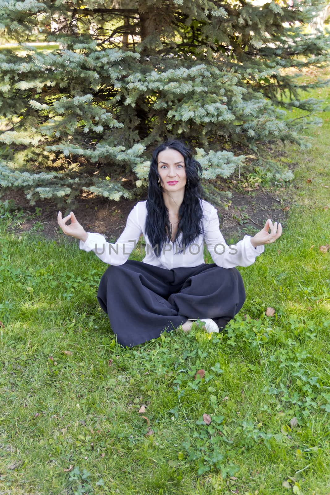 Brunette on green grass in yoga pose by Julialine