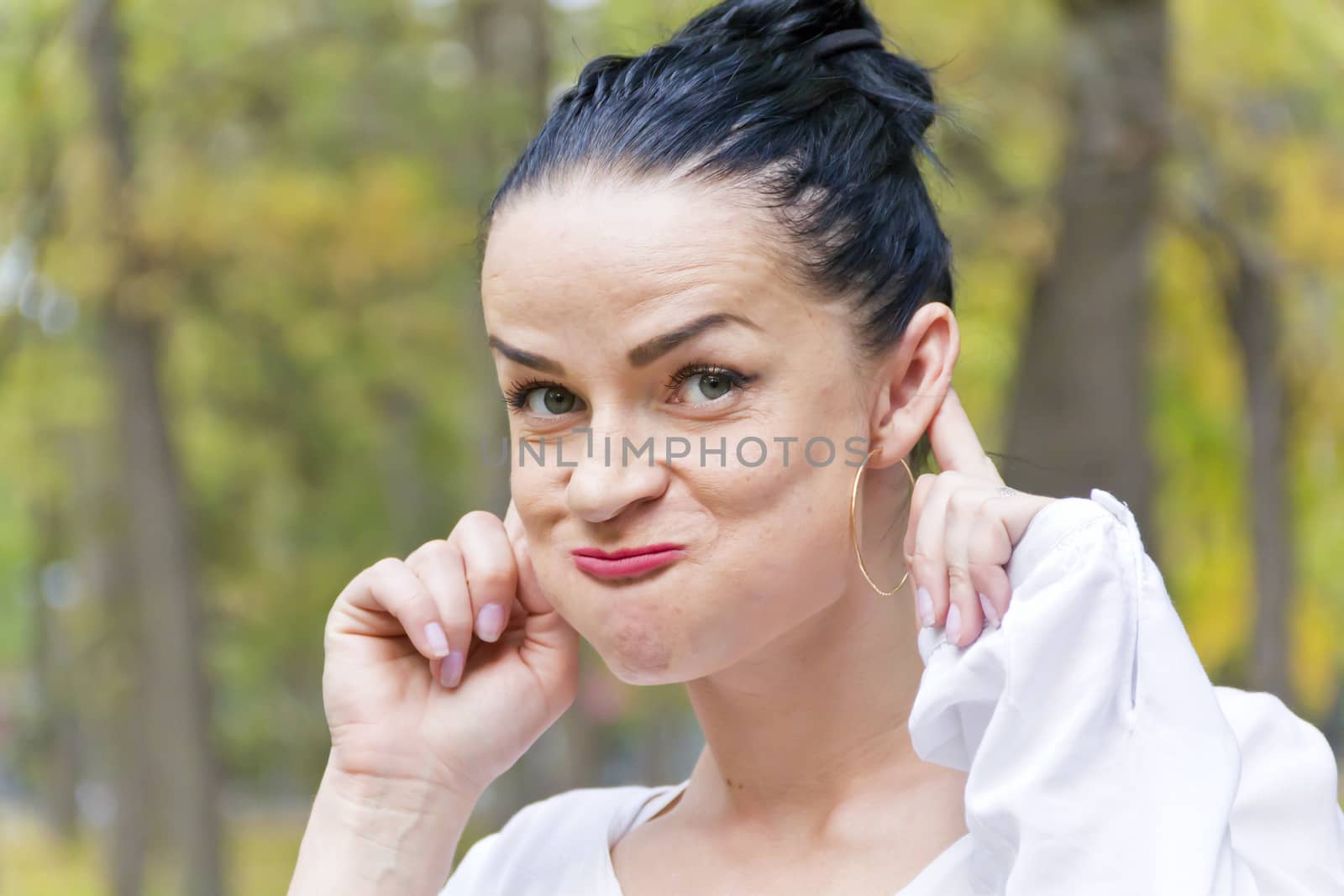 Funny woman with black hair in autumn park