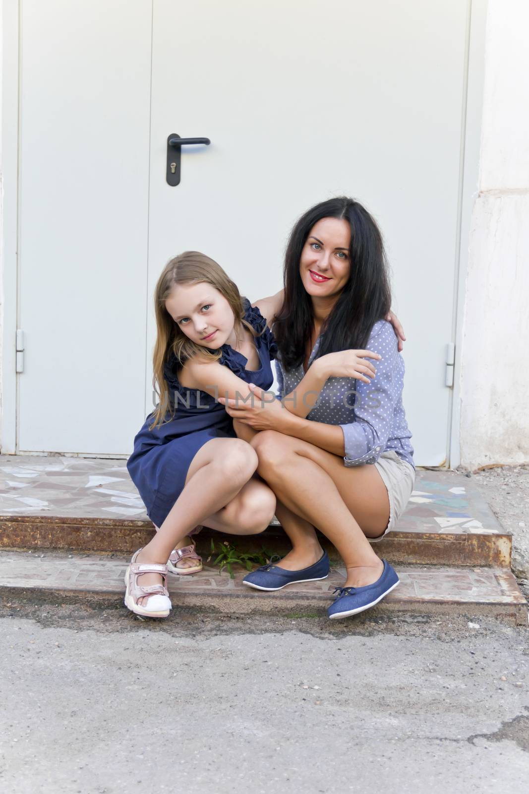 Photo of mother and daughter sitting on the porch