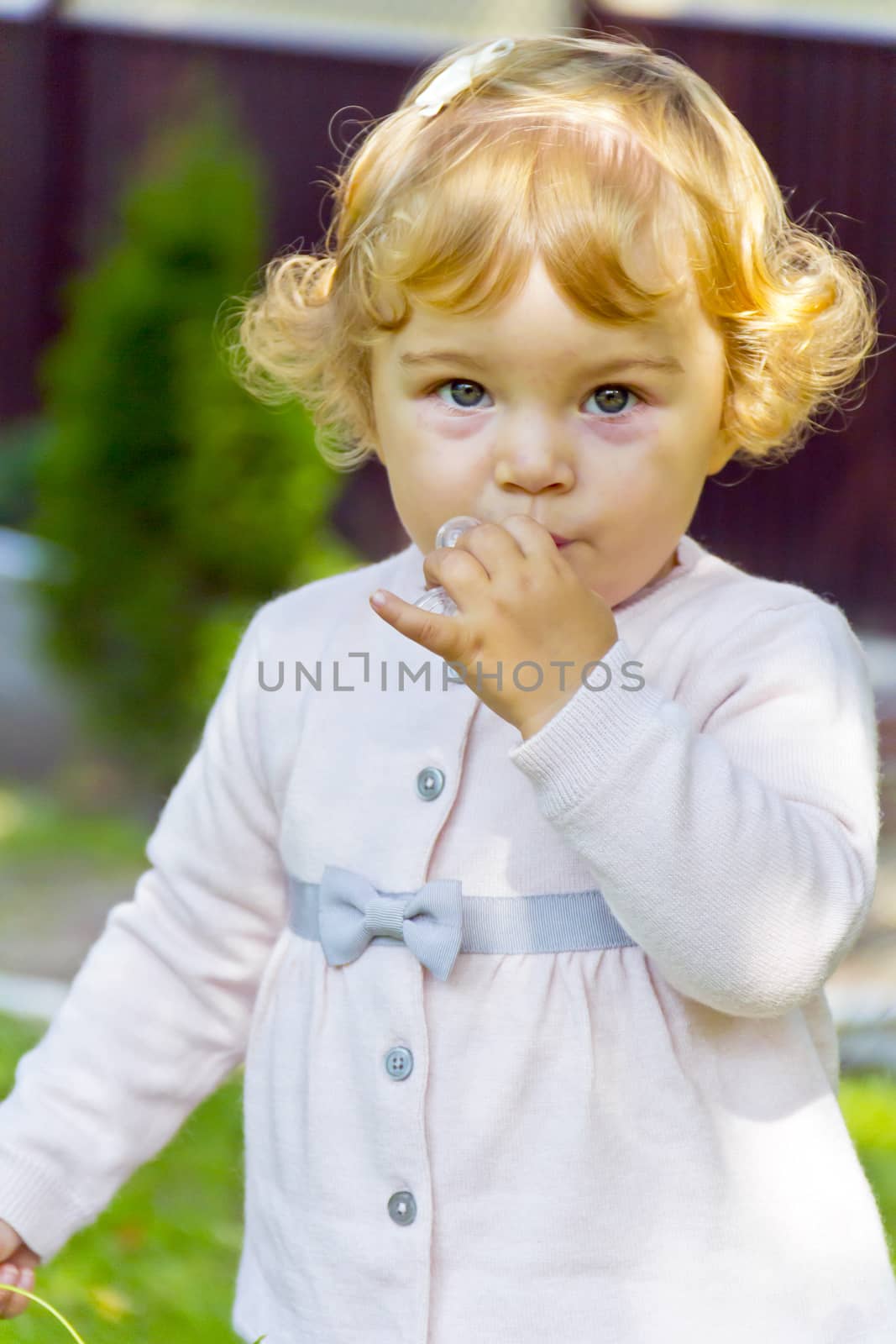 Portrait of cute baby girl with curly blond hair
