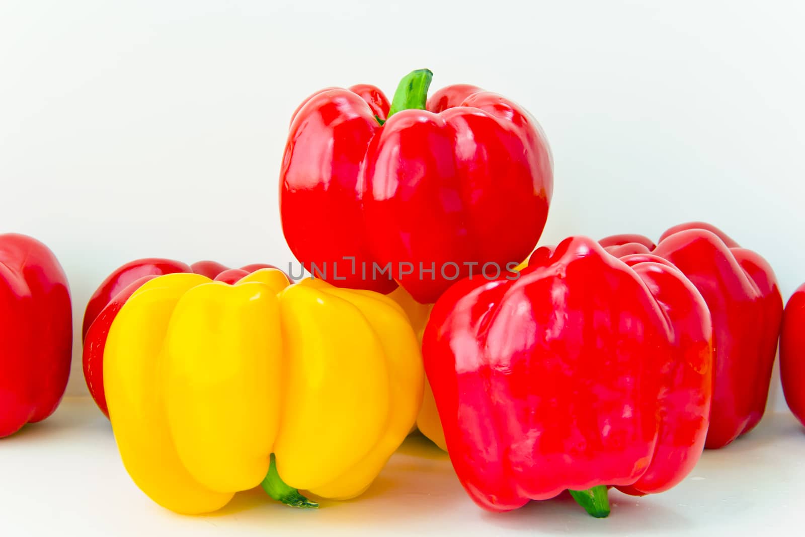 Photo of fresh red and yellow raw pepper on white background