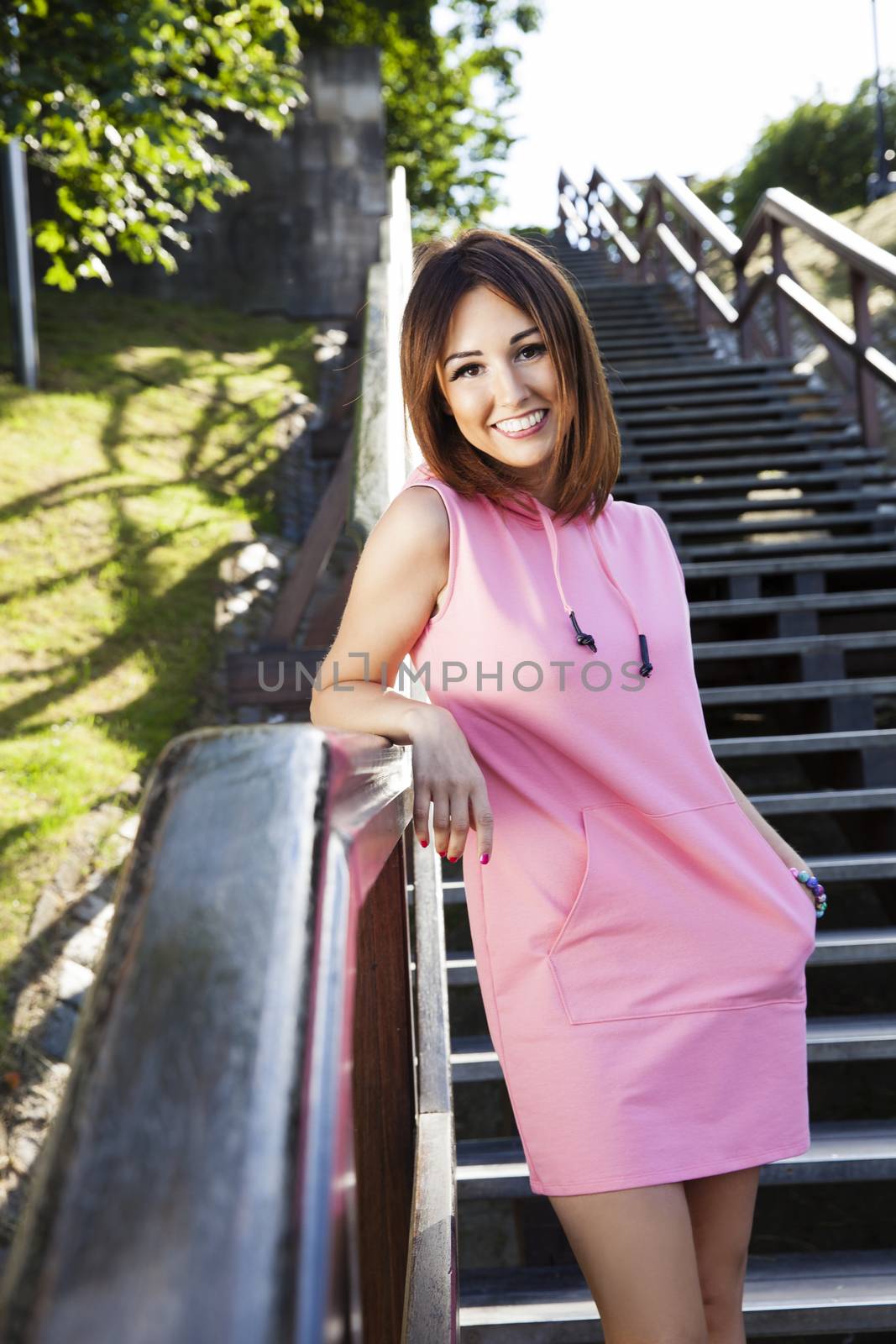Cheerful tourist woman is standing on the steps and smiling to camera.