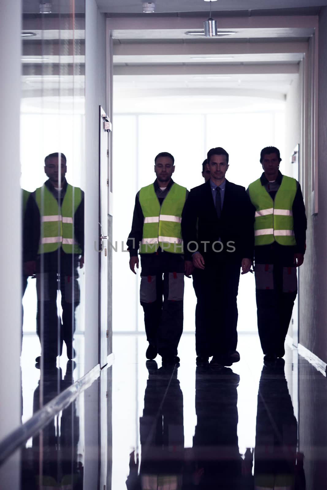 Team of workers and manager walking at the corridor of factory