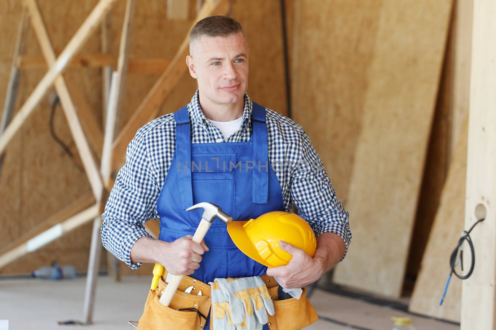 Construction worker with hammer in hand and tools at construction site