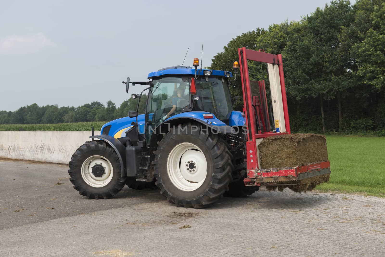 Blue tractor with a red bale slicer
 by Tofotografie