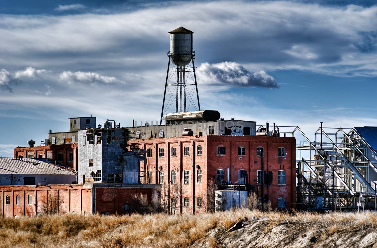 Abandoned sugar mill in a small rual Colorado town against a stormy sky.