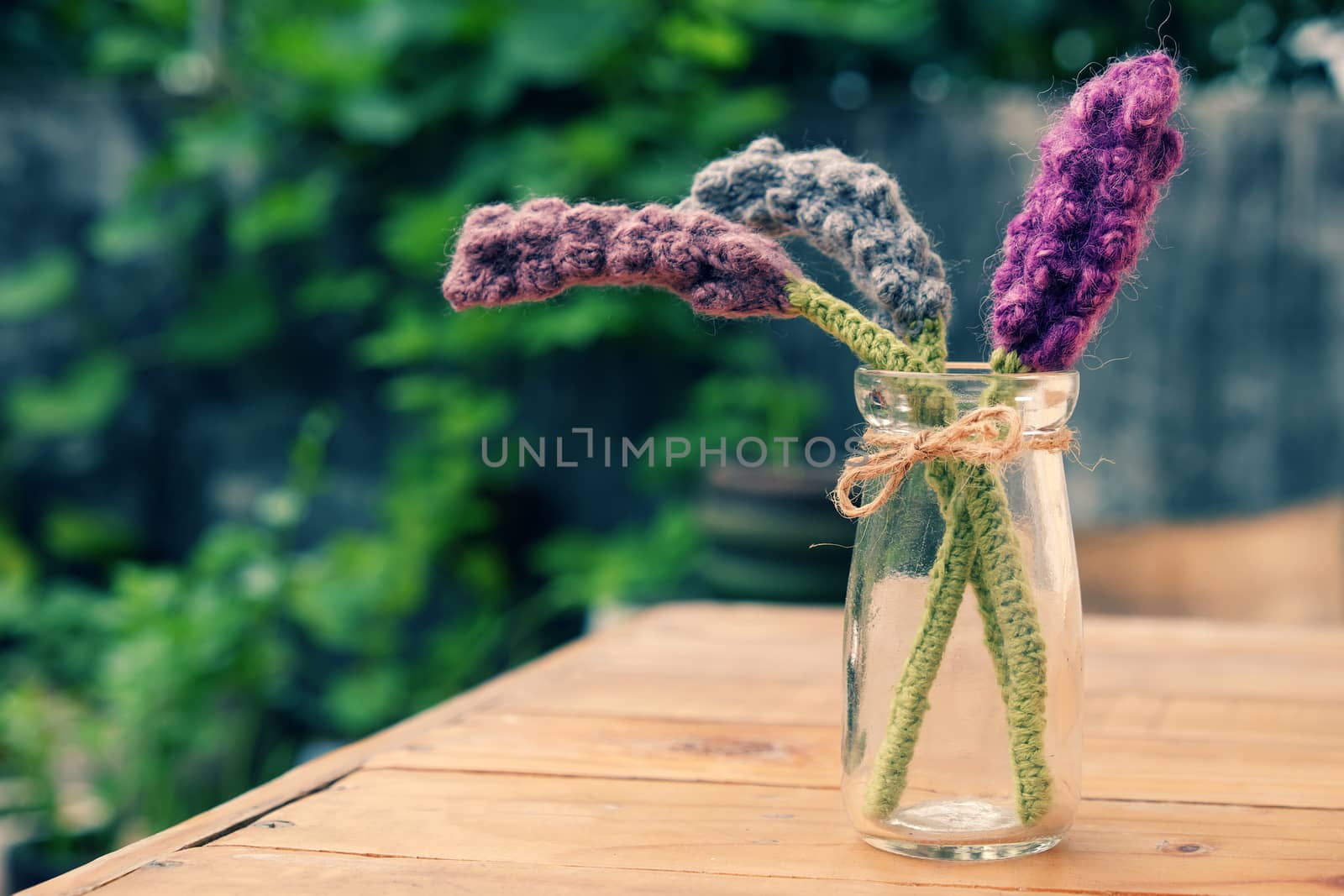 Beautiful knitted lavender flower for home decoration, homemade product knit from yarn, set on table in garden