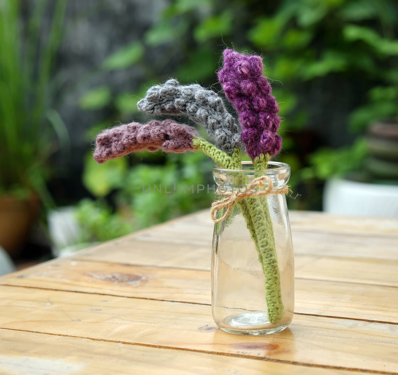 Beautiful knitted lavender flower for home decoration, homemade product knit from yarn, set on table in garden