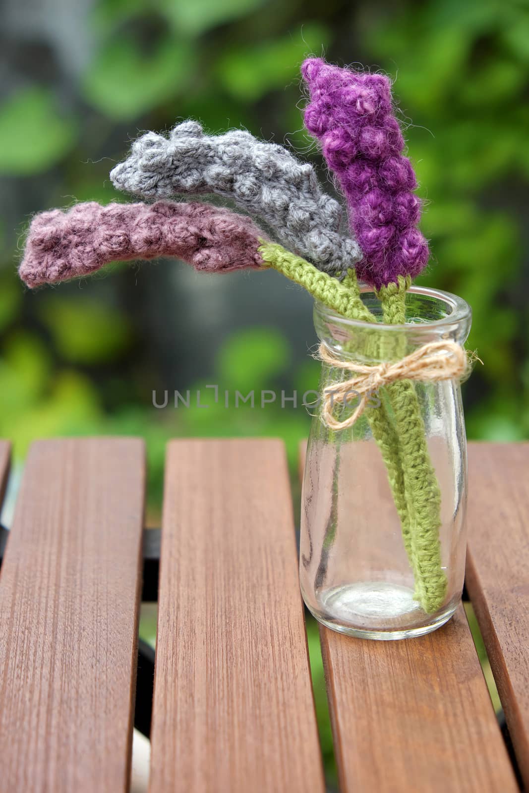 Beautiful knitted lavender flower for home decoration, homemade product knit from yarn, set on table in garden