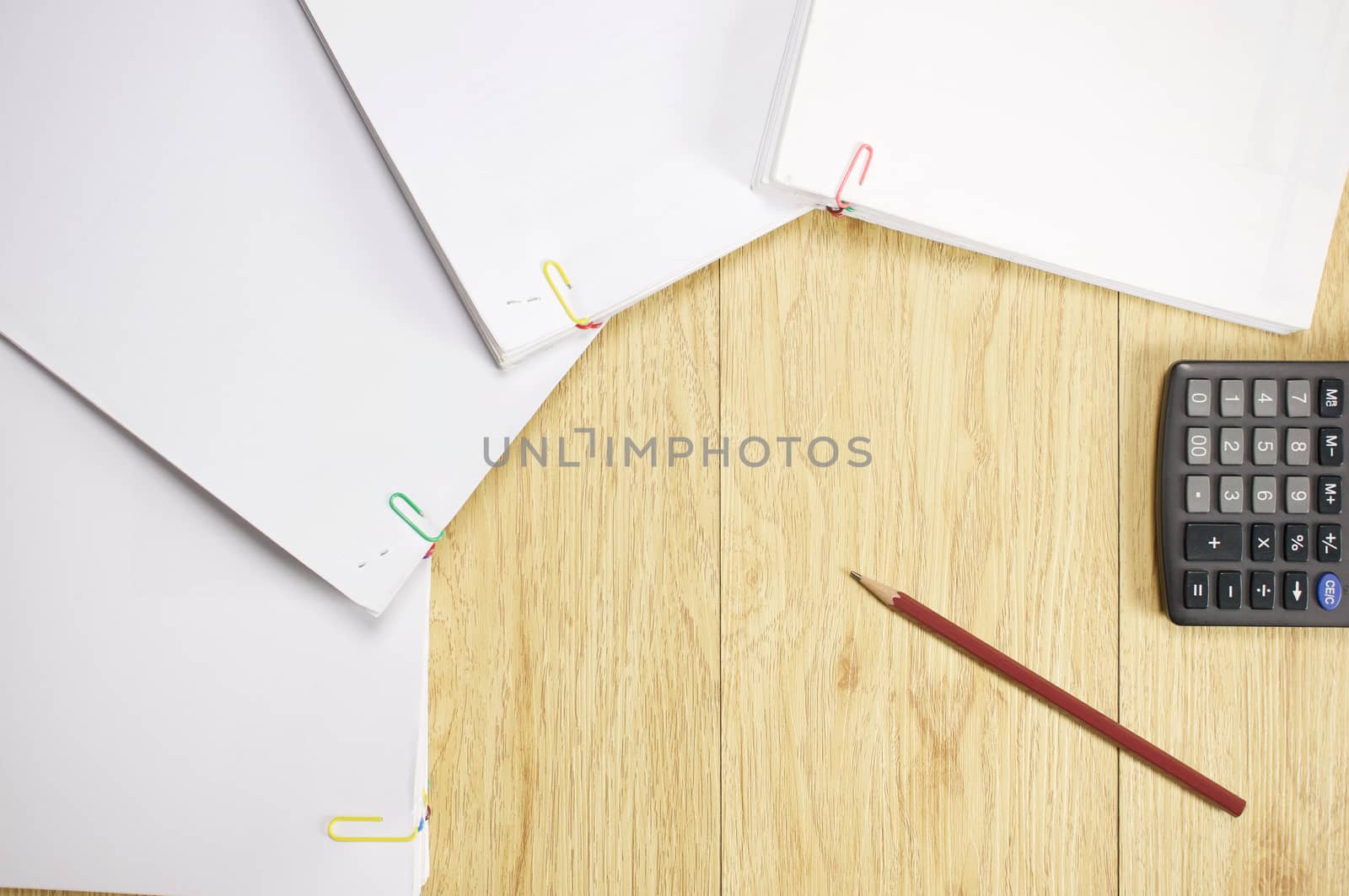 Brown pencil with calculator and stack paperwork of finance account  place on wood background.